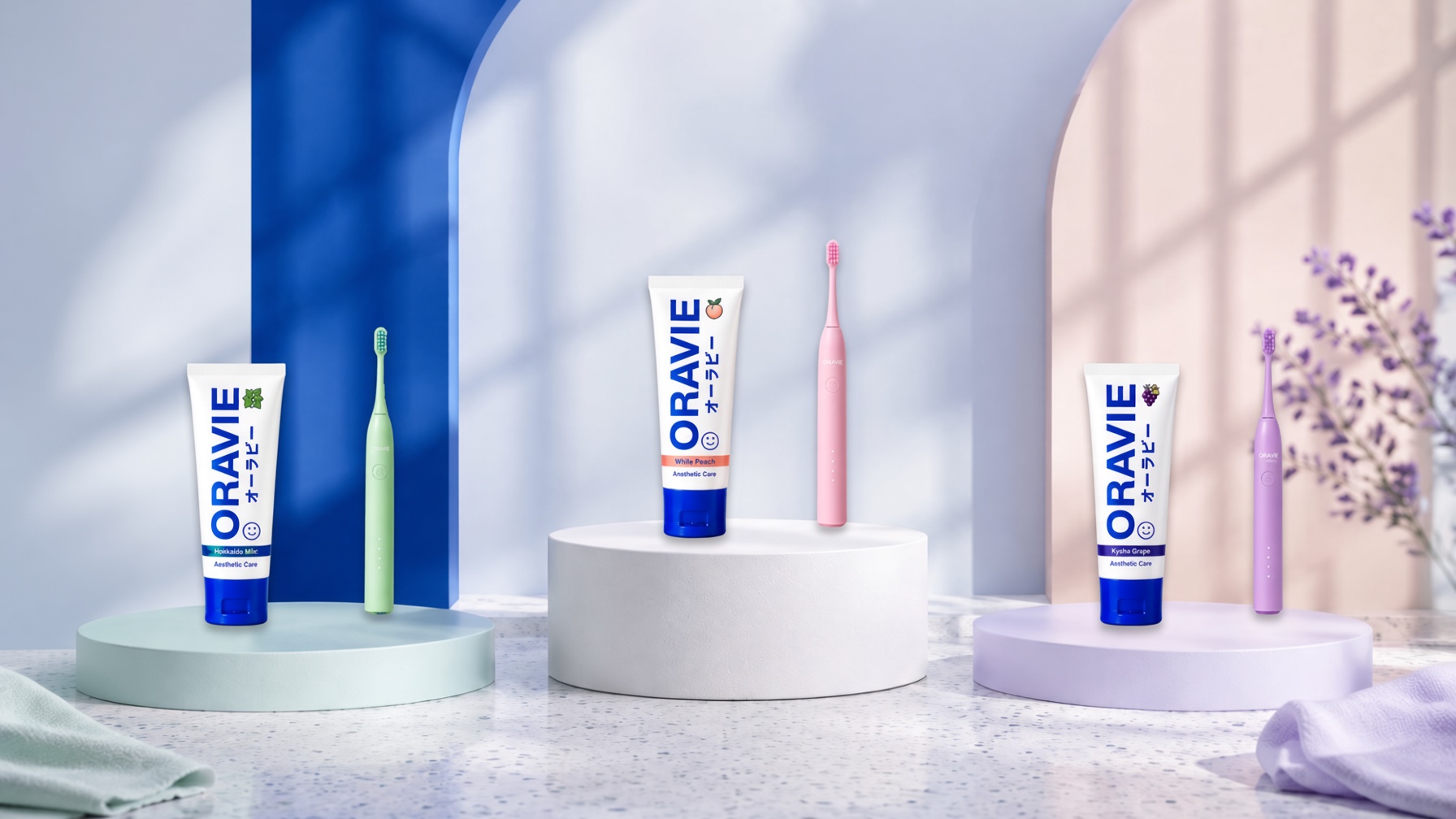 The three Oravie pairs — paste and matching brush — on cobalt plinths